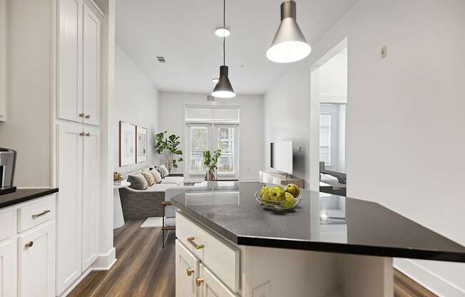 A modern kitchen with a black countertop and white cabinets.