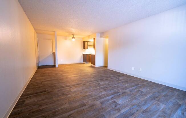 A room with wooden flooring and white walls.