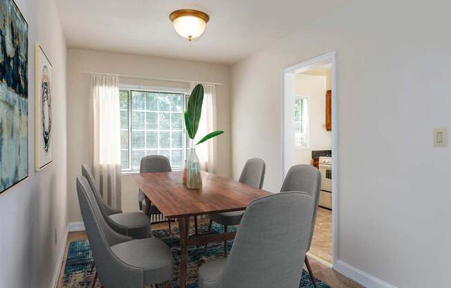 a dining room with a wooden table and chairs at Hamilton Manor Apartments, Hyattsville, MD 20782