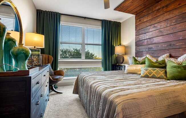 A bedroom with a large bed and a wooden dresser.