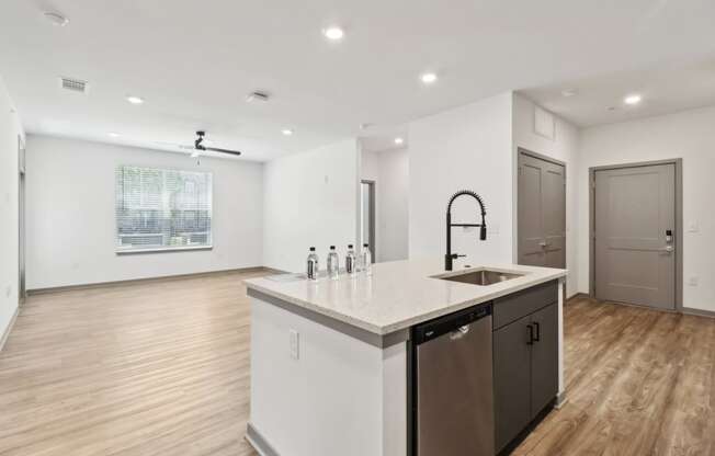 a white kitchen with a large counter top and a sink at The Depot in The Depot Raymore, MO 64083