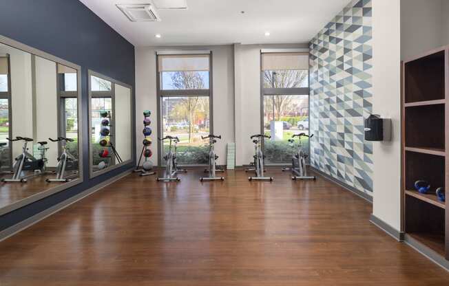 a fitness room with exercise equipment and windows