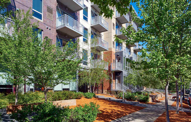 an apartment building with trees and a sidewalk