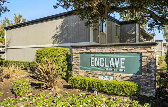 A sign that says "The Enclave at Tiburon Station" in front of a building.
