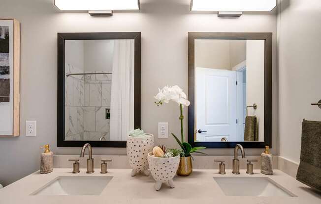 A bathroom with two sinks and a large mirror.