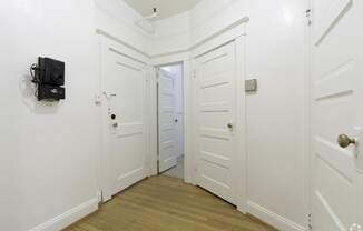 a white hallway with white walls and a door with a black box on the wall at Clay & Tiffany, Portland, OR