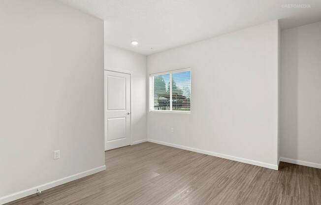 A room with a door and a window with blinds.