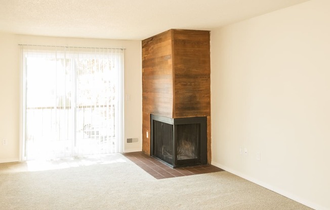 Todd Village vacant apartment living room with a wood burning fireplace and a sliding glass door