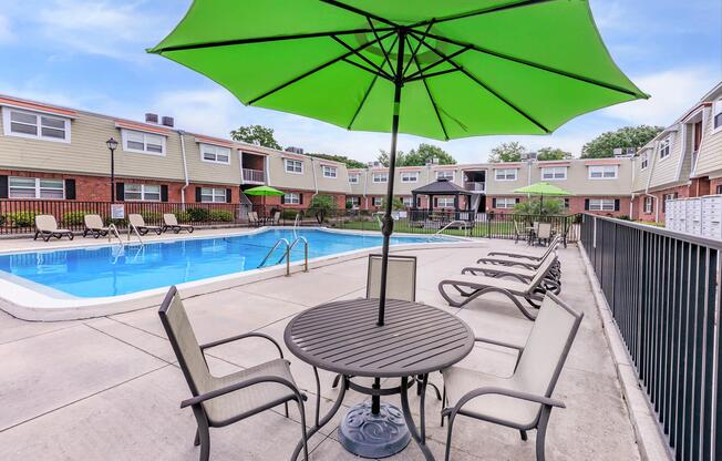 a row of lawn chairs sitting on top of a green umbrella