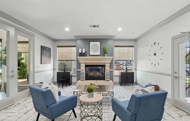 A leasing office with a fireplace and chairs at Encore at Buckingham Apartments in Richardson, TX