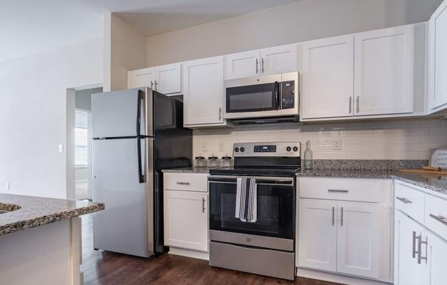 a kitchen with white cabinets and stainless steel appliances