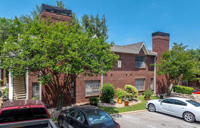 A red brick building with a black car parked in front.