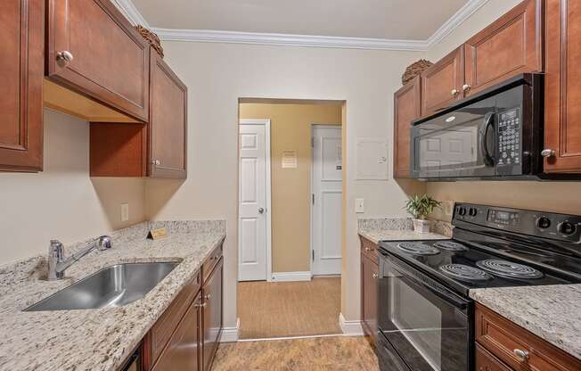 a kitchen with granite counter tops and a black stove and microwave