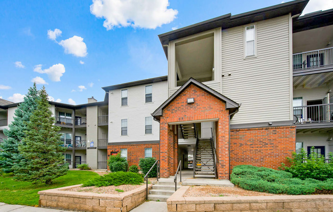 View of the entryway of one of our apartment buildings with stairs and 3 floors at Greensview Apartments in Aurora, CO