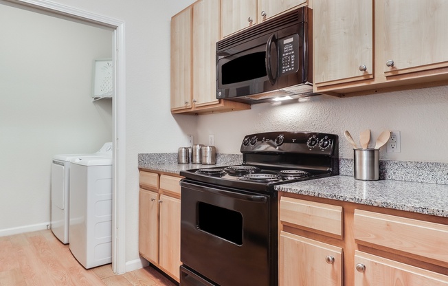 A kitchen with a black stove and wooden cabinets, Plantation Crossing, Lafayette, 70508