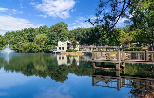 a view of a lake with a dock and a white house