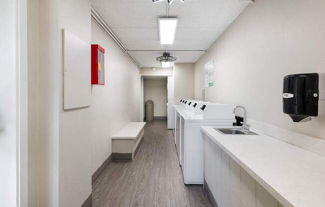 a long white room with a sink and a counter top