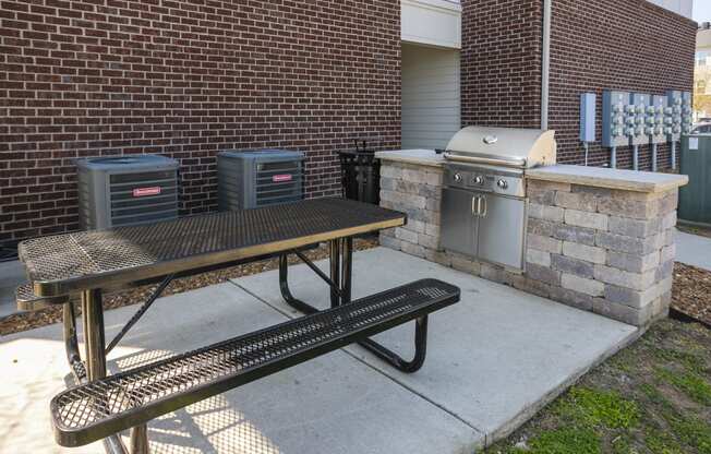 a picnic table and grill in front of a brick building