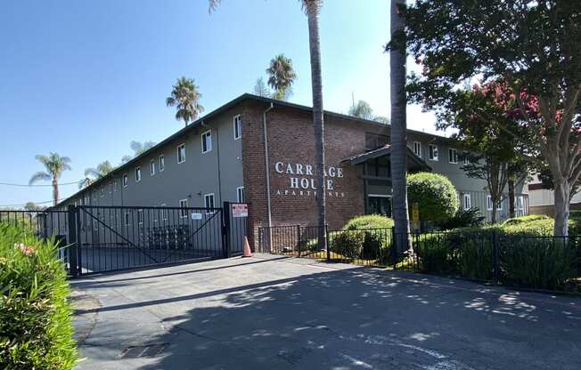 a building with palm trees and a road in front of it