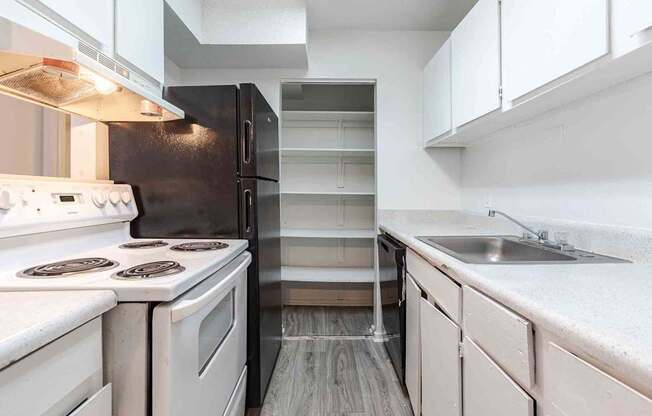 A kitchen with white appliances and cabinets.