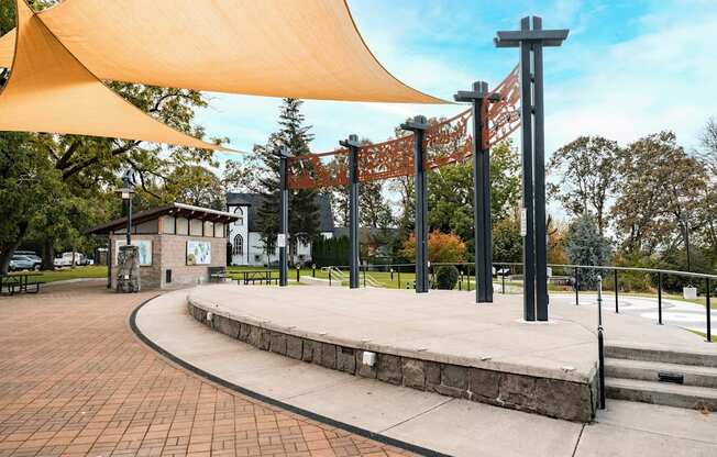 A park with a yellow canopy and a small building.