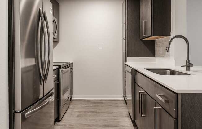 an empty kitchen with stainless steel appliances and a sink
