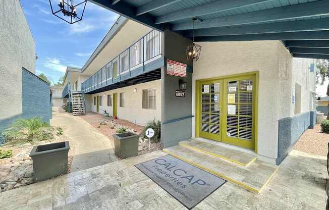 The image shows a building entrance with a sign that reads "ALCAP".