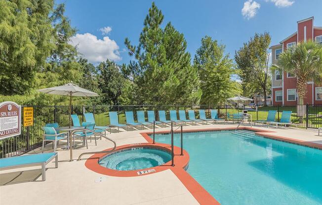 Tallahassee FL apartment complex resort-style swimming pool and spa and lounge chairs at Evergreens at Mahan