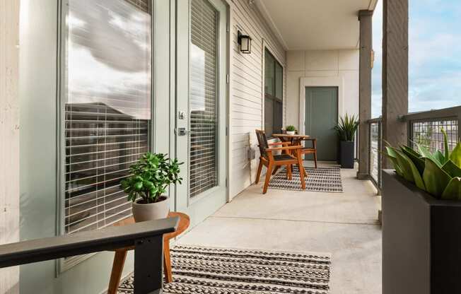 a balcony with a table and chairs and sliding glass doors
