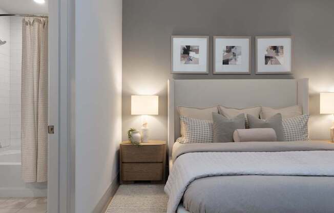 A bedroom with a large bed and a nightstand with a lamp.