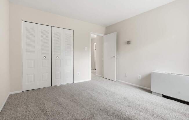A room with a grey carpet and white walls.
