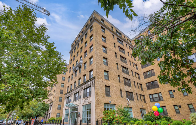 a tall brick building with balloons in front of it