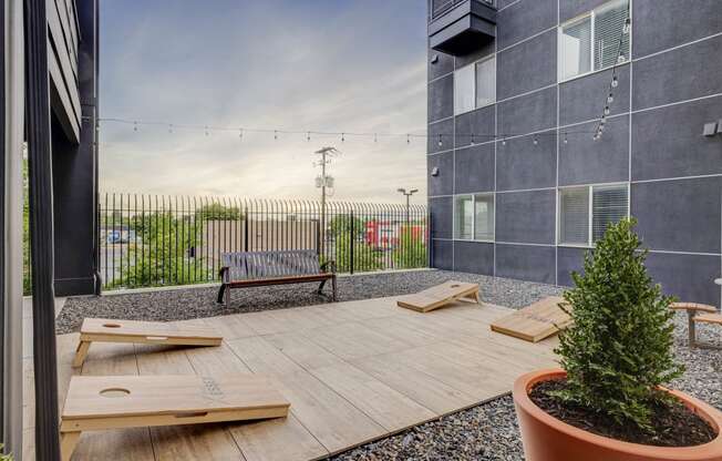 a patio with benches and a tree in front of a building