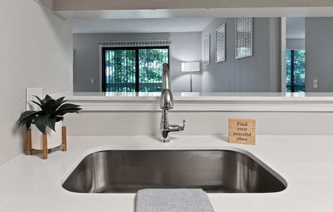 a large stainless steel sink in a white kitchen