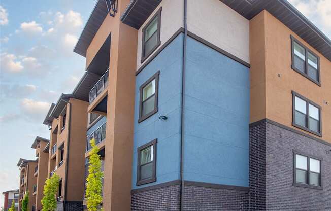 A modern apartment building with a mix of blue and brown exterior walls.