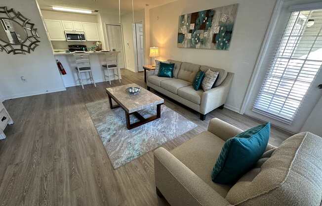 A living room with a couch, coffee table, and a painting on the wall.