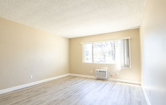 an empty room with wood floors and a window