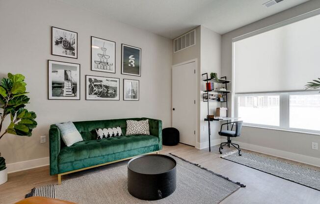 a living room with a green couch and a window