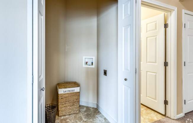 a hallway with two doors and a basket on the floor