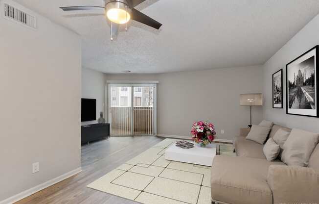 a living room with a couch and a ceiling fan  at Eastwood Crossings, Kansas City, Missouri