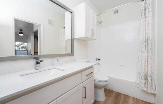 A white bathroom with a sink, toilet, and bathtub.