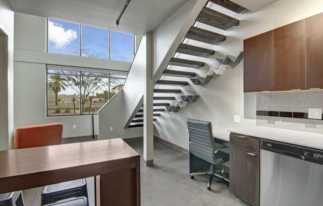 a kitchen with a table and chairs next to a staircase