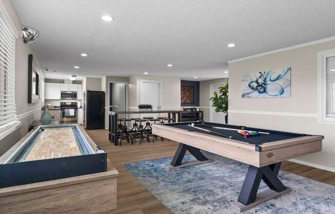 A pool table in a room with a dining table and chairs.