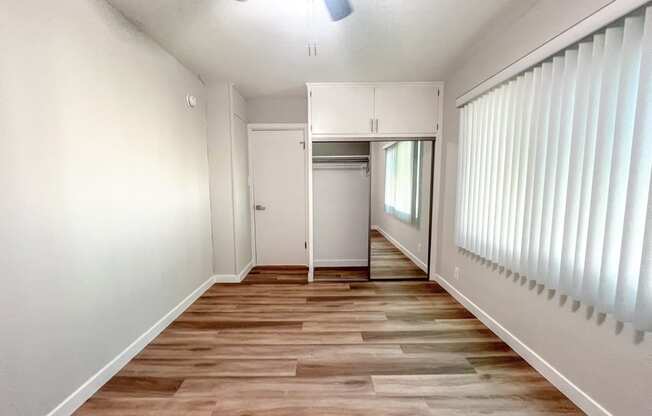 an empty living room with white walls and wood floors