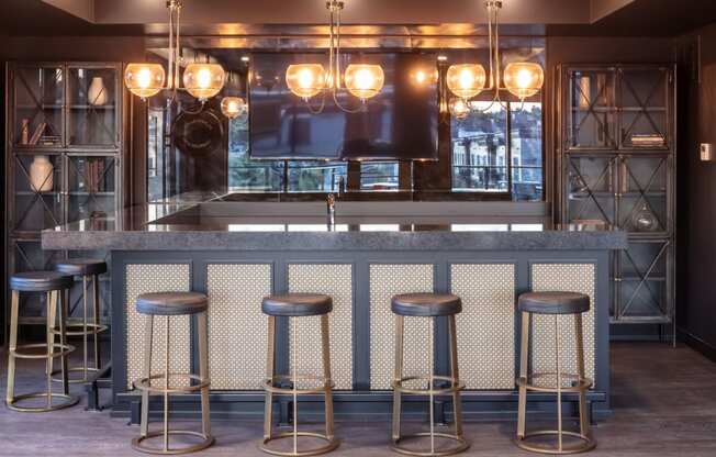 a bar with stools and a television at Maven on Broadway, Rochester, Minnesota