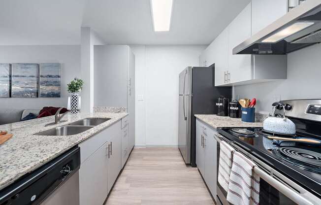 A modern kitchen with a black fridge and stove top oven.