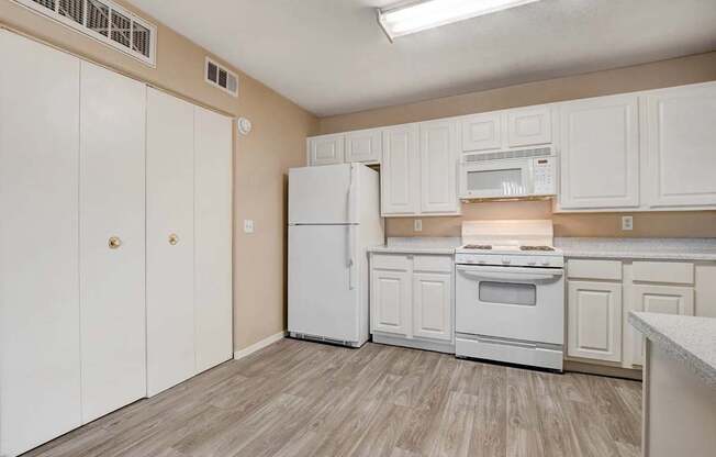 A kitchen with white appliances and cabinets.