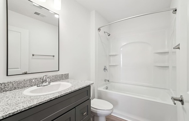 A white bathroom with a sink, toilet, and bathtub.