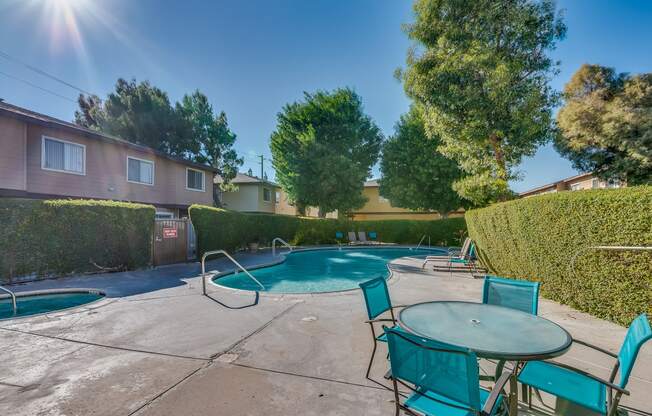 a pool with a hot tub and a table and chairs