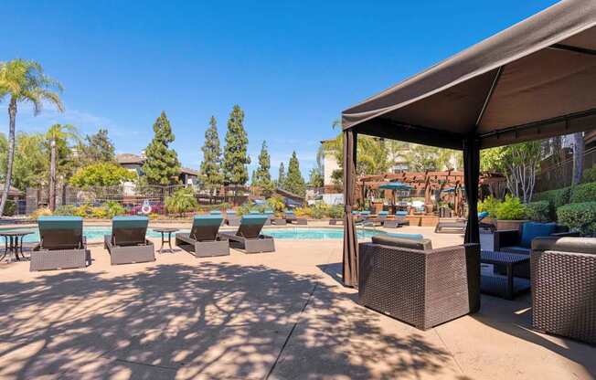 A poolside area with lounge chairs and a canopy.